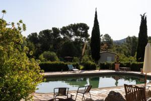 a swimming pool with two chairs and a table at Ecolodge Carpe Diem El Perelló in Perelló