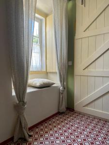 a room with a window and a bed in front of a door at Casa tio Manuel in São Martinho das Amoreiras