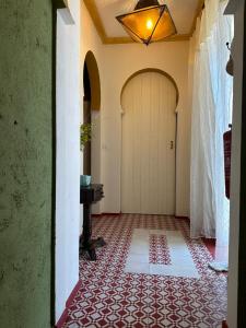 a hallway with a white door and a red tile floor at Casa tio Manuel in São Martinho das Amoreiras +3 photos