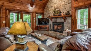 a living room with a stone fireplace in a cabin at Among the Trees in Epworth
