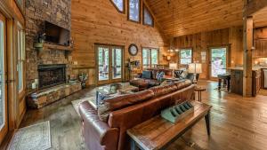 a living room with leather furniture and a stone fireplace at Living Waters in Blue Ridge