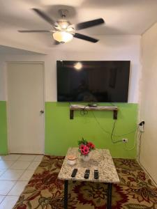 a living room with a table and a flat screen tv at Excente alojamiento in Zaragoza