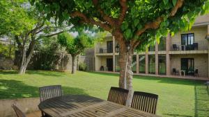 a wooden table and chairs under a tree in a yard at Can 28 in Torroella de Montgrí