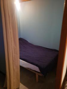 a small bed in a room with a curtain at Maison in Camiers