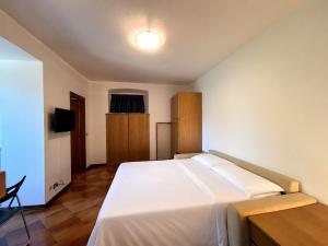 a bedroom with a large white bed and a desk at Casa Leima - Larihome A83 in Gera Lario