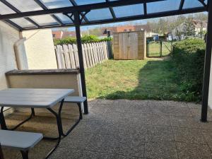 a picnic table and a bench on a patio at Maison in Camiers