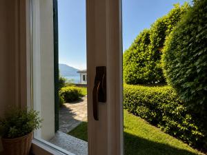 an open door with a view of a garden at Casa Leima - Larihome A83 in Gera Lario