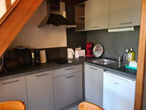 a small kitchen with white cabinets and a sink at Maison in Camiers