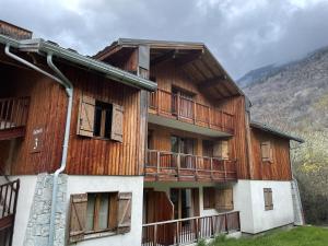 a wooden building with balconies on the side of it at Appartement Orelle spa et piscine in Orelle