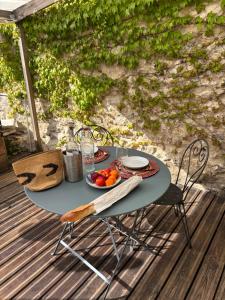 a table with a bowl of fruit on a deck at Maison Floréal Giverny in Giverny