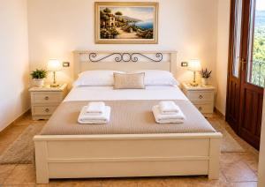 ein Schlafzimmer mit einem großen Bett, auf dem zwei Handtücher liegen in der Unterkunft Grimaldi B&B in San Vito lo Capo