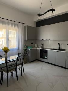 a kitchen with white cabinets and a table and chairs at Slow Living Home in Kilada