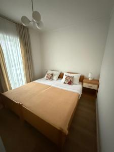 a bedroom with a bed with white sheets and a window at Apartment Kristijan in Pag