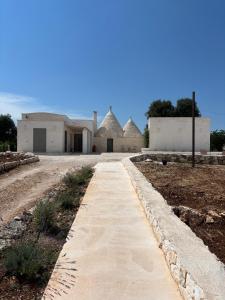 a walkway leading to a building in a field at Trullo botanico in Ceglie Messapica