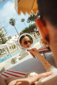 a man is looking at his reflection in a mirror at Kimpton Los Monteros Marbella by IHG in Marbella +291 photos