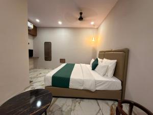 a bedroom with a bed and a table in it at Hotel Fortune, Althan in Surat +7 photos