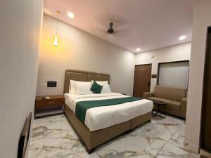 a hotel room with a bed and a couch at Hotel Fortune, Althan in Surat