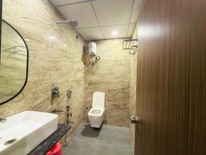 a bathroom with a toilet and a sink at Hotel Fortune, Althan in Surat