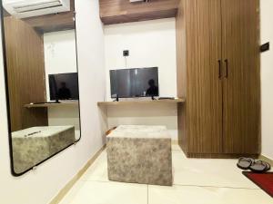 a room with a mirror and a stool and a tv at Hotel Fortune, Althan in Surat