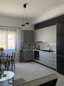 a kitchen with white cabinets and a table and a dining room at Slow Living Home in Kilada