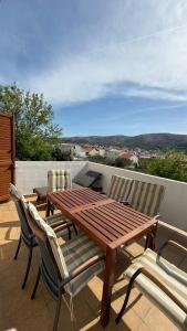 a wooden table and two chairs on a patio at Apartment Kristijan in Pag