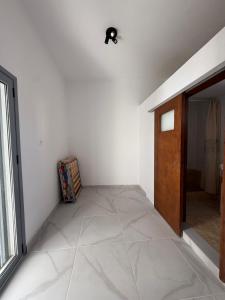 a hallway with a door and a tile floor at Slow Living Home in Kilada