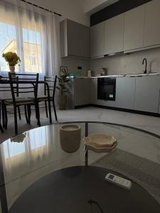 a living room with a glass table and a kitchen at Slow Living Home in Kilada +7 photos