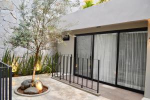 a house with a fence and a tree in a courtyard at Sweven Hotel Boutique in Guadalajara