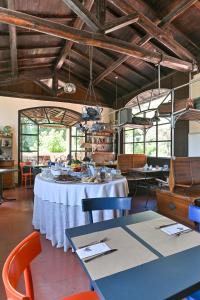 a dining room with a white table and chairs at La Macchia in Spoleto