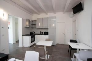 a kitchen with white cabinets and tables and chairs at Casa Terry in Ronchi dei Legionari