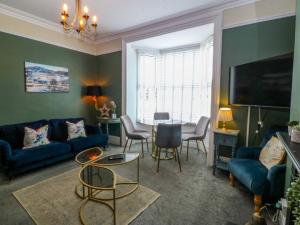 a living room with a blue couch and a table at Jack's House in Tywyn
