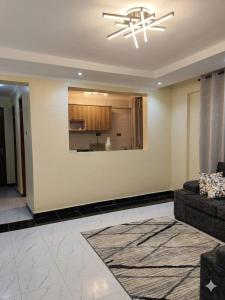 a living room with a couch and a kitchen at Sky-Host, Dulham suite in Homa Bay