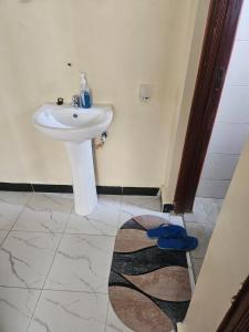 a bathroom with a sink and a white sink at Sky-Host, Dulham suite in Homa Bay