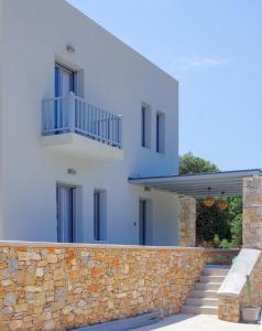 a white house with a stone wall and stairs at MarGio Olive House in Galissas