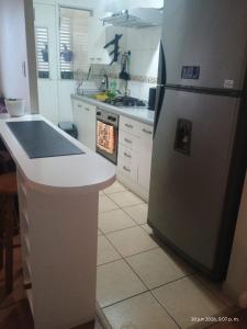 a kitchen with a refrigerator and a counter top at M&L departamento in Limache