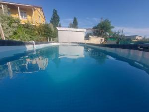 a large pool of blue water in a yard at Отель Семейный in Zatoka