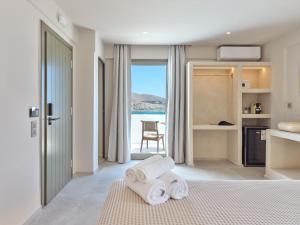 a bedroom with towels on a bed with a view of the ocean at Kali Naousa in Naousa