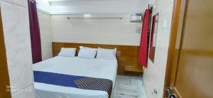 a small room with a bed and a window at Universal Inn in Chennai +3 photos