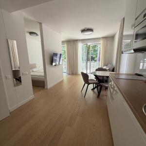 a kitchen and living room with a table and a dining room at Nerija in Juodkrantė