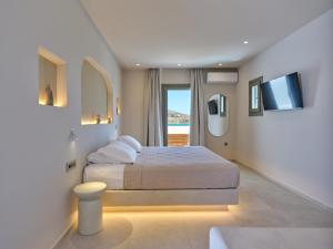 a hotel room with a bed and a television at Kali Naousa in Naousa