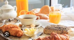 a table with a breakfast of pastries and coffee and orange juice at hugotel in Francescas