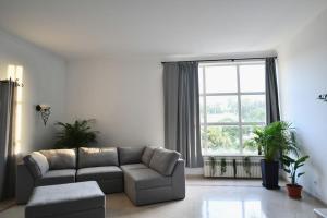 a living room with a couch and a large window at Casa do Sol Wellness Home in Óbidos