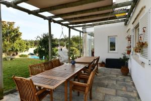 a wooden table and chairs on a patio at Casa do Sol Wellness Home in Óbidos