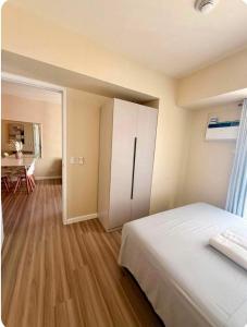 a bedroom with a white bed and a table at Avida Towers Riala Tower 1 in Cebu City +3 photos