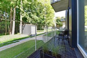 a screened in porch with a table and a fence at Nerija in Juodkrantė