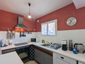 una piccola cucina con pareti rosse e un lavandino di Lavanda Calme et climatisé au cœur de Molitg les Bains a Moltig les Bains Altre 8 foto