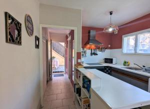 una cucina con pareti rosse e un piano di lavoro bianco di Lavanda Calme et climatisé au cœur de Molitg les Bains a Moltig les Bains