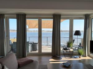 a living room with a view of the ocean at Luxuswohnung Pazifik WESER WELLNESS WHIRLPOOL in Brake