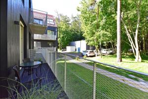 a balcony with a table and a fence at Nerija in Juodkrantė +7 photos