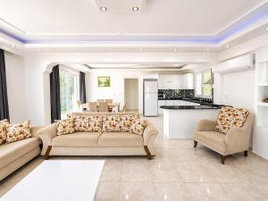 a living room with two couches and a kitchen at Villa Fergana in Oludeniz